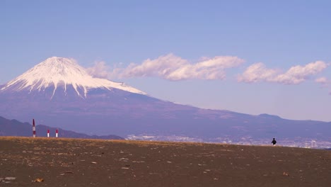 Persona-Solitaria-Caminando-En-Una-Playa-Abierta-En-Japón-Con-El-Monte-Fuji-En-Segundo-Plano