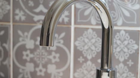 Water-is-dripping-from-a-chrome-bathroom-tap