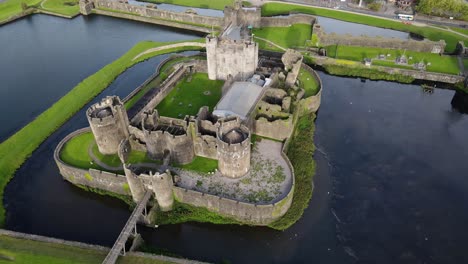 Aerial-circling-shot-of-Caerphilly-Castle-in-Southern-Wales,-United-Kingdom