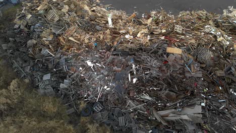 Aerial-Flyover-Of-Dumped-Wood-At-A-Trash-Waste-Junkyard,-Global-Warming-And-Environmental-Issue