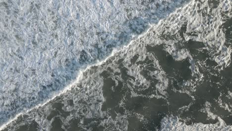 Diagonal-Shot-Of-Foamy-Surf-Waves-Roll-Over-Ocean-During-Sunset-In-Summer-At-Long-Beach-Island,-New-Jersey,-USA