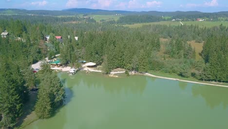 Lake-House-Resort-Surrounded-by-Green-Forests---Aerial-Flyaway-Overview