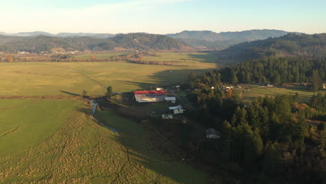 Vista-Panorámica-De-Las-Tierras-Agrícolas-Rurales-En-Myrtle-Point,-Oregon-Durante-La-Puesta-De-Sol---Retirada-Aérea