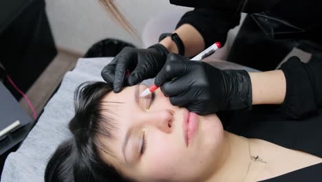 Master-makes-eyebrow-eyeliner-in-a-beauty-salon