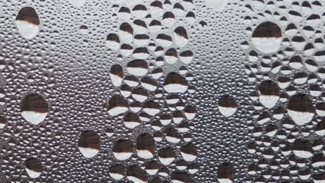 Water-droplets-on-foggy-window-glass,-background,-extreme-closeup