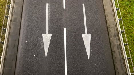 Car-changing-from-right-lane-to-the-left-lane-on-a-black-asphalt-equipped-with-white-arrows-to-guide-the-vehicles-in-Gdynia