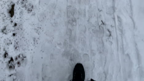 FPV-Man's-legs-walking-on-a-snowy-street