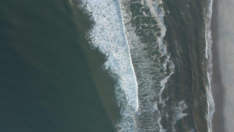 Weiße-Wellen,-Die-In-Den-Sand-Rollen---Luftaufnahme-Von-Oben-Langsam