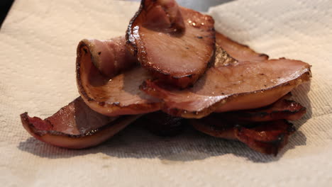 Placing-Freshly-Cooked-Homemade-Bacon-Slices-In-Paper-Towel-To-Absorb-Excess-Oil