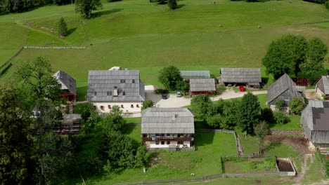 Aerial-view-of-Alpine-Valley-with-rustic-farm-in-front,-Jezersko,-Slovenia,-European-Alps,-scenic-mountain-landscape