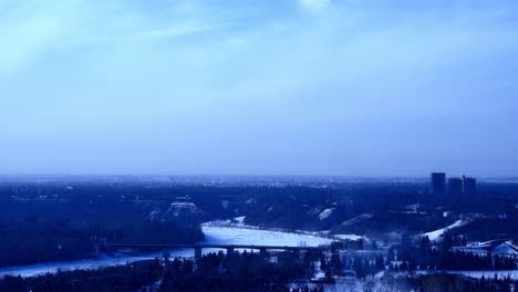 4k-Zeitraffer-Winter-Groat-Road-Nw-Brücke-über-Schneebedeckte-North-Saskatchewan-River-Wolken,-Die-Sich-Bei-Fünfundvierzig-Grad-Bewegen-Siluotte-Stadtbild-Skyline-In-Blauen-Abstufungen-Mit-Lotsa-Dampfwolken
