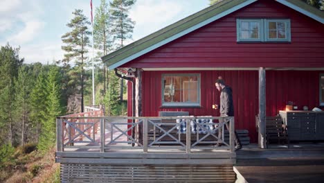 Man-Walking-In-The-Porch-Of-The-Red-Cabin-In-Norway
