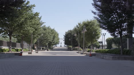 Walkway-in-Belvedere-Plaza-in-Louisville,-Kentucky-on-a-beautiful-summer-day-with-the-statue-of-George-Rogers-Clark-on-the-horizon