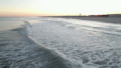 Krachende-Meereswellen-Bewegen-Sich-Langsam-Am-Sandstrand-Während-Des-Sonnenuntergangs-Auf-Long-Beach-Island-In-New-Jersey,-Usa