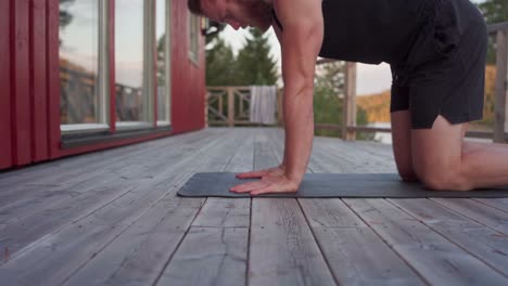 Mann-Macht-Handübungen-Auf-Der-Yogamatte-Auf-Holzboden