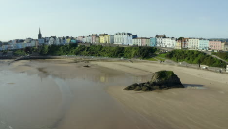 Drone-aerial-footage-of-Tenby-beach-and-town-in-Pembrokeshire,-South-Wales-with-colourful-houses-on-sea-front