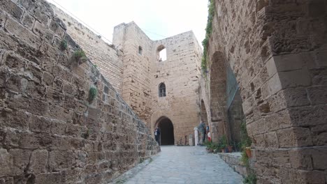 Korridor,-Der-Von-Den-Burgmauern-Von-Kyrenia-Kommt,-Mit-Blick-Auf-Alte-Steinmauern---Breiter-Gimbal-Push-in-Shot