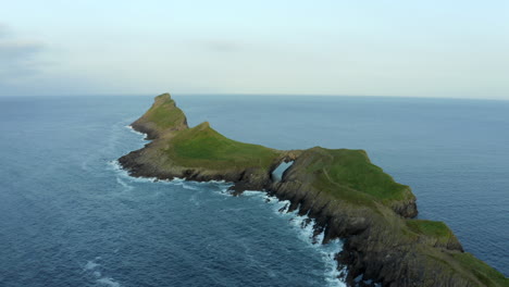 Drone-footage-of-Worms-head-in-Rhossili-bay-with-coastal-cliffs-in-the-Gower-peninsula-in-Swansea,-South-Wales