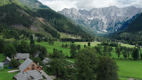 Aerial-view-of-Alpine-Valley-with-rustic-farm-in-front,-Jezersko,-Slovenia,-European-Alps,-scenic-mountain-landscape