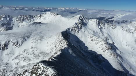 Aerial-view,-snow-capped-peaks-of-Rocky-Mountains-range-USA-on-sunny-winter-day