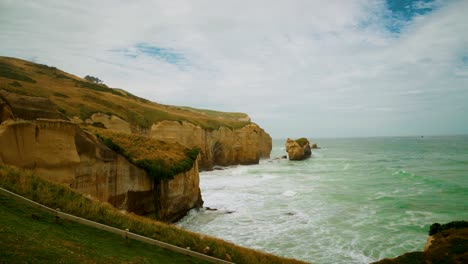 Klippen-Entlang-Der-Küste-In-Neuseeland-Mit-Wellen,-Die-Die-Klippenwand-Treffen