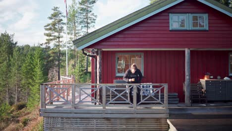 Man-Holding-A-Cup-Of-Coffee-Sits-On-The-Chair-In-The-Cabin-On-A-Sunny-Day