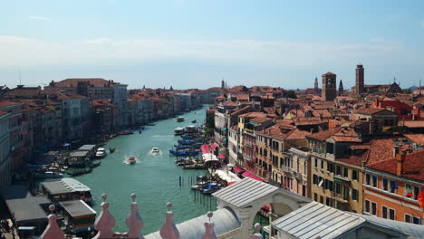 Beautiful-cityscape-shot-of-Venice-City-during-sunny-day-with-medieval-buildings-and-driving-boats-along-water-canal
