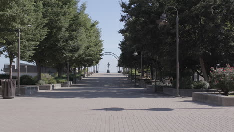 Push-down-walkway-at-Belvedere-Plaza-in-Louisville,-Kentucky-towards-George-Rogers-Clark-statue-on-a-beautiful-summer-day