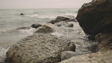 Waves-Crashing-Onto-Rocky-Coastline-During-Summer,---Close-Up-Shot