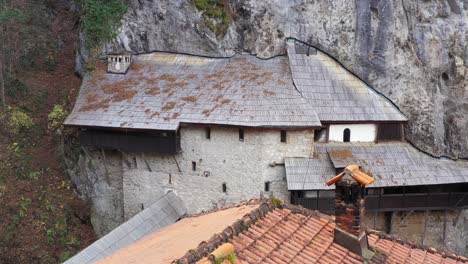 Monastery-built-into-mountainside-rock,-old-historical-architectural-building