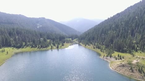 Slow-moving-aerial,-the-drone-flies-above-the-blue-lake
