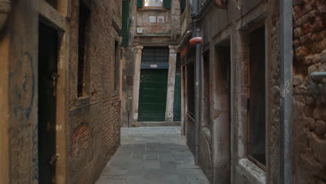 Slow-steady-pov-walk-in-narrow-alley-surrounded-by-old-historic-buildings-during-daytime