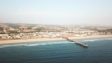 Aerial-forward-over-Pismo-city-pier-and-beach,-California