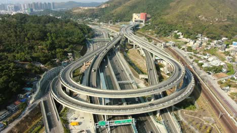 Traffic-on-a-Massive-highway-interchange-with-multiple-levels-and-loop-shaped-road-in-Hong-Kong,-Aerial-time-lapse