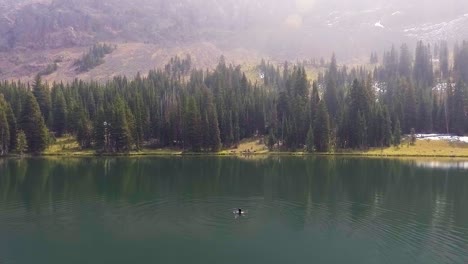Drone-flies-above-woman-to-reveal-beautiful-lake-and-mountains