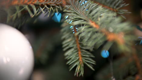 Christmas-tree-leaf-close-up-view-with-balls-and-ornaments,-selective-focus