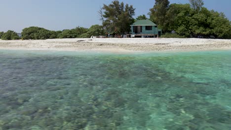 Drone-Orbitando-Una-Isla-Con-Una-Cabaña-En-Las-Maldivas