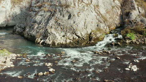 Wunderschöner-Süßwassergebirgsbach-Mit-Kristallklarem-Türkisfarbenem-Wasser,-Das-Hinter-Den-Bergklippen-Fließt