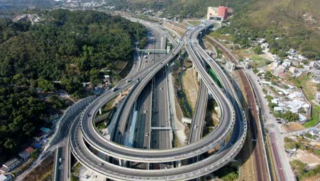 Tráfico-En-Un-Intercambio-Masivo-De-Carreteras-Con-Varios-Niveles-Y-Carretera-En-Forma-De-Bucle-En-Hong-Kong,-Vista-Aérea
