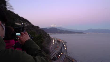 Photographer-wearing-facemask-during-Covid-Pandemic-taking-pictures-of-landscape-with-Mount-Fuji