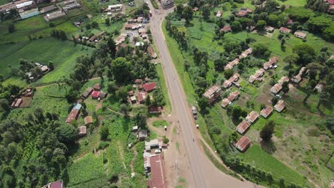 Vista-Aérea-De-La-Carretera-En-La-Zona-Rural-De-Kenia-En-El-Valle-Bajo-La-Montaña-Kilimanjaro-En-Un-Día-Soleado,-Tiro-De-Drones-De-60-Fps-De-Arriba-Hacia-Abajo