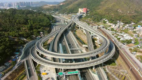Verkehr-Auf-Einem-Massiven-Autobahnkreuz-Mit-Mehreren-Ebenen-Und-Schleifenförmiger-Straße-In-Hongkong,-Luftbild