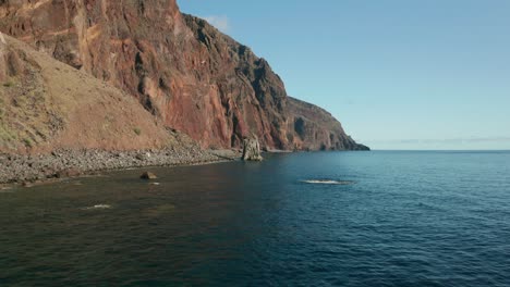 Steep-volcanic-cliffs-at-shore-next-to-Atlantic-Ocean,-aerial