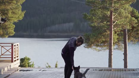 Man-With-Dog-Stands-And-Admire-The-Beautiful-Lake-In-Norway