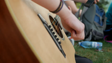 a-close-up-of-a-person-playing-the-guitar-on-a-mountain