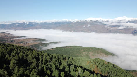 Very-dense-fog-above-the-big-valley-in-La-Cerdanya,-with-snowy-mountains-on-the-horizon