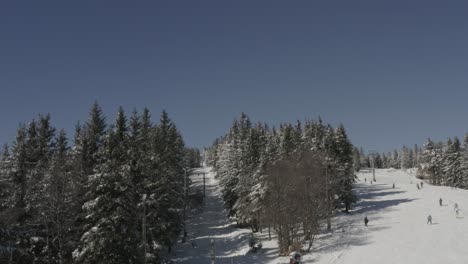 Ski-drag-lift-at-Kope-winter-resort-Slovenia-aside-from-Ribnica-track,-Aerial-flyover-shot