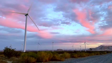 Alternative-energy-wind-turbine-farm-timelapse-against-dramatic-pink-sunset-sky
