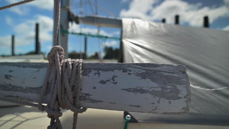Rope-Tied-On-Horizontal-Wooden-Part-Of-A-Sailing-Boat---close-up,-slider-right