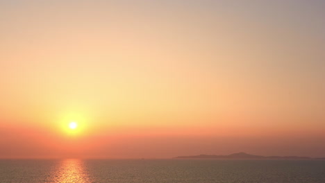 A-large-golden-sun-sets-above-the-ocean-horizon